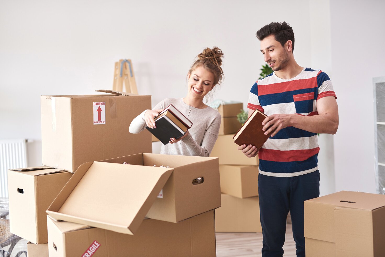 Couple Unloading Boxes into New Home